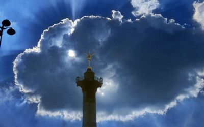 The sun blasts through some clouds behind the colonne de Juillet in place de la Bastille / Cityscapes  photography by Photographer David Henry | STRKNG