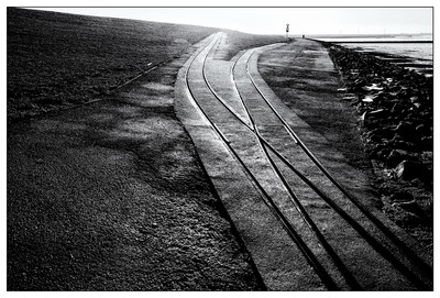 Am Nordseedeich / Schwarz-weiss / schwarzweissfotografie,Fotokunst,fineartphotography,Lorenschienen,Nordsee,Nordfriesland,Natur,Schleswig-Holstein