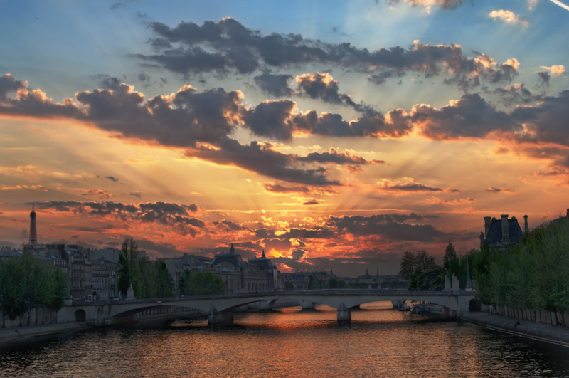 The sun setting behind pont du Carrousel, with the musée d’Orsay on the left, and the Louvre. - &copy; David Henry | Cityscapes