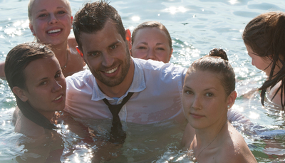 Junger Mann im Anzug im Wasser mit vielen Frauen / Menschen  Fotografie von Fotograf Wolf | STRKNG