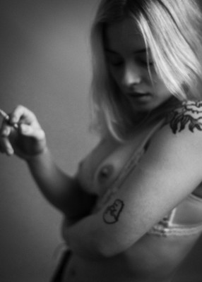 » #4/8 « / with cigarette / Blog post by <a href="https://strkng.com/en/photographer/lichtundnicht/">Photographer LICHTundNICHT</a> / 2022-01-30 11:04 / Nude / nude,portrait,aktportrait,akt,teilakt,breast,nipple,tattoo,model,young,cigarette,homestudio,monochrome,blackandwhite